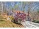 Charming gray home with an elevated deck and a spacious driveway, nestled amongst trees and natural vegetation at 980 Pine Grove Pointe Dr, Roswell, GA 30075