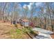 Gray home with a long driveway, nestled amongst trees and natural light, with lots of privacy for any homeowner at 980 Pine Grove Pointe Dr, Roswell, GA 30075