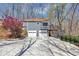 Two-story gray home with a three-car garage, and a large parking pad nestled amongst natural vegetation at 980 Pine Grove Pointe Dr, Roswell, GA 30075