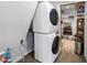 Efficient laundry area with stacked washer and dryer and storage shelving at 980 Pine Grove Pointe Dr, Roswell, GA 30075