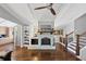 Cozy living room featuring stone fireplace, wood floors, and built-in bookshelves at 980 Pine Grove Pointe Dr, Roswell, GA 30075