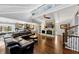 Bright and airy living room with hardwood floors, stone fireplace, and an open layout to the kitchen at 980 Pine Grove Pointe Dr, Roswell, GA 30075