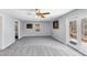 Spacious living room with neutral walls, soft carpet, ceiling fan, and outdoor access at 980 Pine Grove Pointe Dr, Roswell, GA 30075