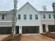Modern townhome exterior with white brick, large windows, and a two-car garage at 105 Priestwood Ln, Acworth, GA 30102