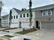A row of townhomes, each with attached garages, showcasing a combination of brick and painted exteriors at 105 Priestwood Ln, Acworth, GA 30102