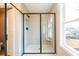 Modern glass enclosed shower with tile surround, a built-in seat, and a window for natural light at 105 Priestwood Ln, Acworth, GA 30102