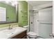 Clean bathroom with wood vanity, glass shower door and green walls at 1703 Mission Park Dr, Loganville, GA 30052