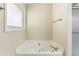 Bright bathroom with a garden tub, tile walls, and brushed nickel fixtures at 1703 Mission Park Dr, Loganville, GA 30052