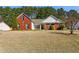 Charming brick and white home featuring a well-manicured lawn and beautiful landscaping at 1703 Mission Park Dr, Loganville, GA 30052