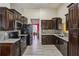 Modern kitchen featuring dark wood cabinetry, stainless steel appliances, and granite countertops at 1703 Mission Park Dr, Loganville, GA 30052