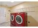 Well-equipped laundry room with red washer and dryer, and wire shelving for organization at 1703 Mission Park Dr, Loganville, GA 30052