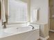 Bright bathroom with a large white soaking tub and a window at 173 Northshore Xing, Dallas, GA 30157