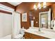 Cozy bathroom featuring a shower over bath, white sink, and mirror, with brown walls and trim at 173 Northshore Xing, Dallas, GA 30157