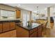 Open kitchen features an island with granite countertops, wood cabinets and stainless steel appliances at 173 Northshore Xing, Dallas, GA 30157