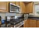 Stylish kitchen with stainless steel gas range, overhead microwave, decorative backsplash and wood cabinets at 173 Northshore Xing, Dallas, GA 30157