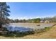 Picturesque pond with houses in the background surrounded by lush trees at 173 Northshore Xing, Dallas, GA 30157