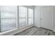 Bright room featuring three large windows, wood-look floors, and a door at 320 Park Ridge Cir, Marietta, GA 30068