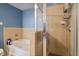 Modern bathroom featuring a separate tub and glass enclosed shower with tan tiling and blue accent wall at 3324 Peachtree Ne Rd # 814, Atlanta, GA 30326