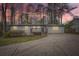 Charming single-story home with a gray exterior, inviting front porch, and a long driveway surrounded by mature trees at 4953 Apple Valley Rd, Douglasville, GA 30135