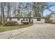 Charming single-story home with a gray exterior, inviting front porch, and a long driveway surrounded by mature trees at 4953 Apple Valley Rd, Douglasville, GA 30135