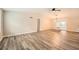 Bright living room featuring gray wood floors, high ceilings, and a modern ceiling fan at 4953 Apple Valley Rd, Douglasville, GA 30135