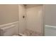 Modern tiled shower with decorative pebble floor and glass enclosure at 4953 Apple Valley Rd, Douglasville, GA 30135