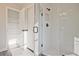 Modern bathroom with a glass shower, neutral tile flooring, and closet with shelving at 101 Priestwood Ln, Acworth, GA 30102