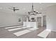 Open-concept living area with a ceiling fan that flows into the kitchen with modern pendant lights at 101 Priestwood Ln, Acworth, GA 30102