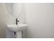 This powder room has a pedestal sink with matte black faucet and a round mirror at 101 Priestwood Ln, Acworth, GA 30102