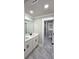 A bathroom with a double vanity, grey floors, white walls, and a black framed shower at 355 Hilltop Cir Sw Ext, Mableton, GA 30126