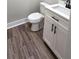 Bathroom with wood-look flooring, a white vanity and black hardware, and a white toilet at 355 Hilltop Cir Sw Ext, Mableton, GA 30126
