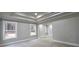 Spacious bedroom featuring a tray ceiling, neutral walls, carpet flooring, and natural light from two windows at 355 Hilltop Cir Sw Ext, Mableton, GA 30126