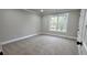 Neutral carpeted bedroom with base molding and a window providing natural light at 355 Hilltop Cir Sw Ext, Mableton, GA 30126