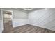 Dining room with detailed wall panels, wood-look floors, and view into kitchen with white cabinets at 355 Hilltop Cir Sw Ext, Mableton, GA 30126
