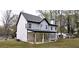 Charming two-story home with white siding, black trim, chimney and a covered back patio with stone pillar supports at 355 Hilltop Cir Sw Ext, Mableton, GA 30126