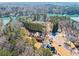 Expansive aerial view of a lakefront home with mature trees and lush landscaping around the property at 3795 Duckcove Way, Cumming, GA 30041