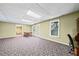 Spacious basement with carpet and table ready for activities, featuring multiple windows at 3795 Duckcove Way, Cumming, GA 30041