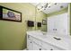 Bathroom featuring white cabinets, a large mirror, and olive-green walls at 3795 Duckcove Way, Cumming, GA 30041