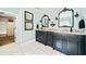 Bright bathroom featuring double vanity with granite countertop, decorative mirrors and white tile flooring at 3795 Duckcove Way, Cumming, GA 30041