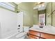 Bathroom with a tub, shower, single sink vanity, and green walls at 3795 Duckcove Way, Cumming, GA 30041