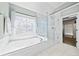 Bright bathroom features a tiled soaking tub with a decorative window and a frameless glass shower at 3795 Duckcove Way, Cumming, GA 30041