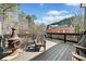 A wooden deck with a fire pit and chairs offers outdoor relaxation with a view of the brick home at 3795 Duckcove Way, Cumming, GA 30041