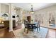 Bright dining area features a modern chandelier, wood flooring, and beautiful backyard views at 3795 Duckcove Way, Cumming, GA 30041
