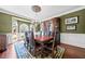 Formal dining room with elegant chandelier, green walls and a large bay window at 3795 Duckcove Way, Cumming, GA 30041