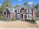 Elegant two-story brick home featuring manicured landscaping, large windows, and a classic architectural design at 3795 Duckcove Way, Cumming, GA 30041
