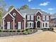 Stately brick home with manicured landscaping, black shutters, and a charming curved walkway to the front door at 3795 Duckcove Way, Cumming, GA 30041