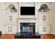 Close-up of a fireplace with a black marble hearth, surrounded by custom shelving at 3795 Duckcove Way, Cumming, GA 30041