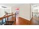 Elegant hallway with hardwood floors and wrought iron staircase, leading to a bedroom with a red ceiling at 3795 Duckcove Way, Cumming, GA 30041