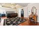 Well-lit main bedroom with a chandelier, complemented by hardwood floors and a patterned black floral rug at 3795 Duckcove Way, Cumming, GA 30041