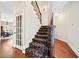 Carpeted staircase with wrought iron railing and hardwood flooring in the entryway at 3795 Duckcove Way, Cumming, GA 30041